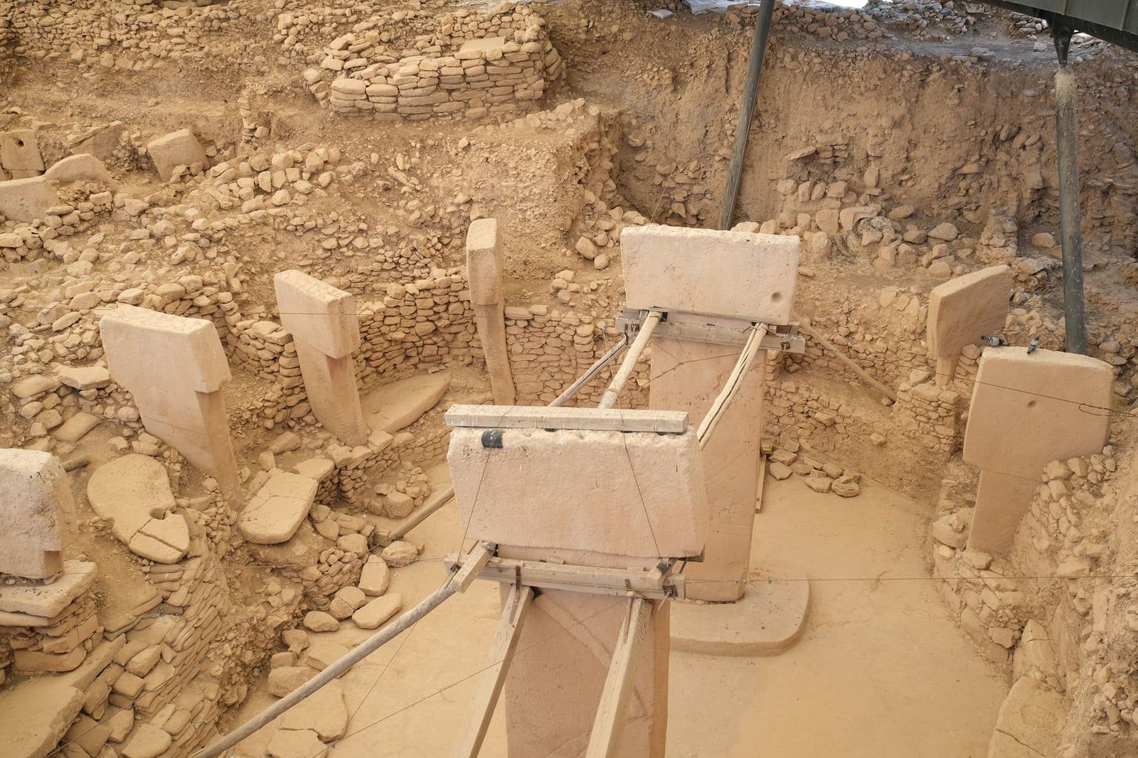 Overhead view of Enclosure D at Göbekli Tepe, showing its two tall central T-shaped pillars surrounded by a ring of megaliths set into circular stone walls.